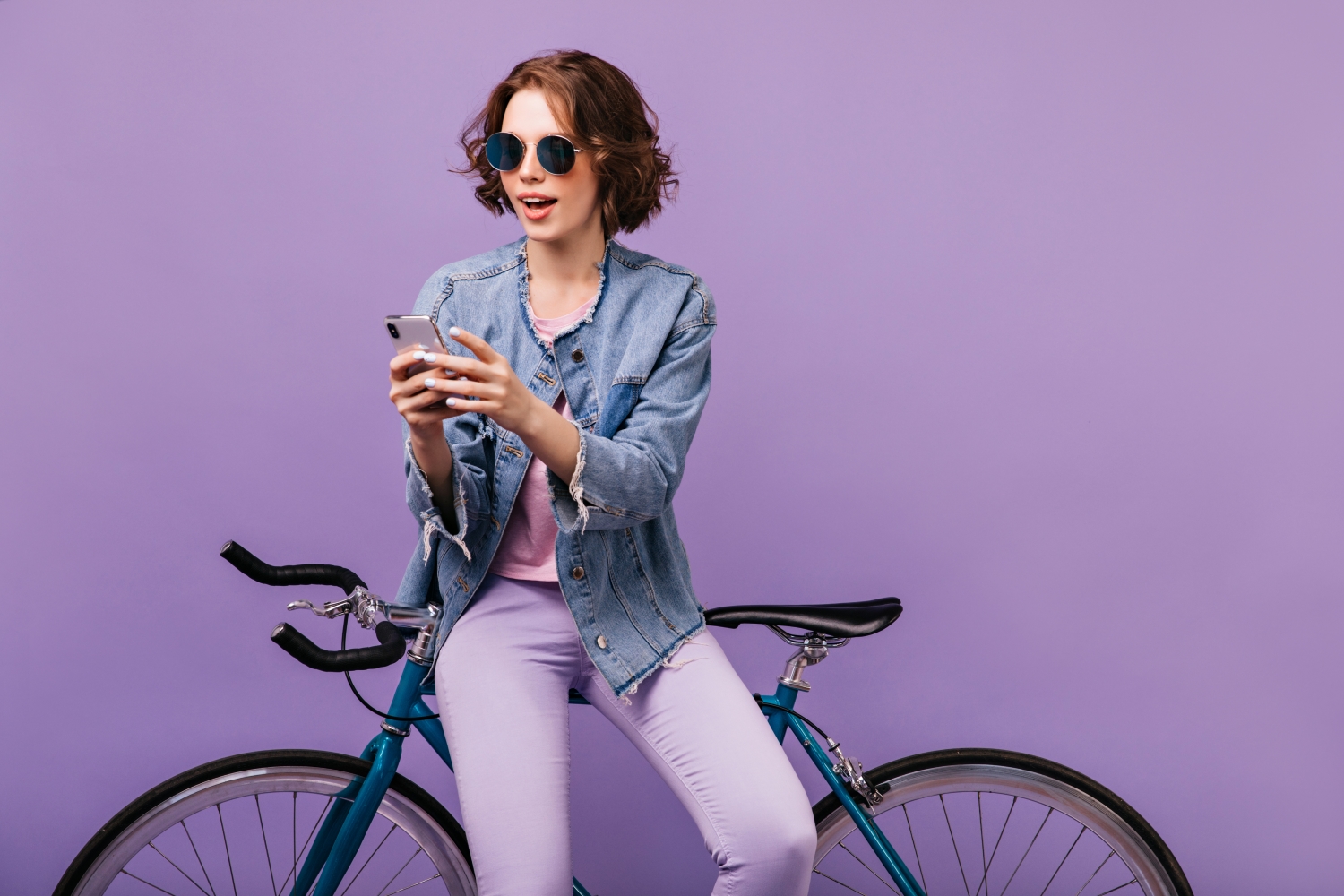 Person mit Fahrrad vor violettem Hintergrund