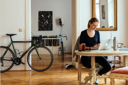 Person am Schreibtisch mit Fahrrad im Raum
